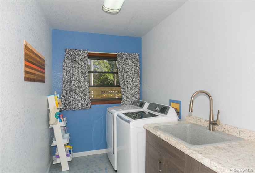 This Laundry Room was recently renovated with new cabinets, counters, new sandstone sink,  Floor is painted concrete!