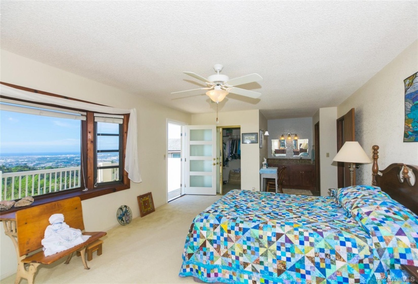 Another view of the master bedroom suite.  Bathroom is straight ahead and has double sinks.  There is a walk in closet to the left straight ahead!  This recent $4,000 door to the lanai, complete with a security door, opens up to the expansive open lanai looking out to your view!  Bay window to the left gives you good light in this large room!