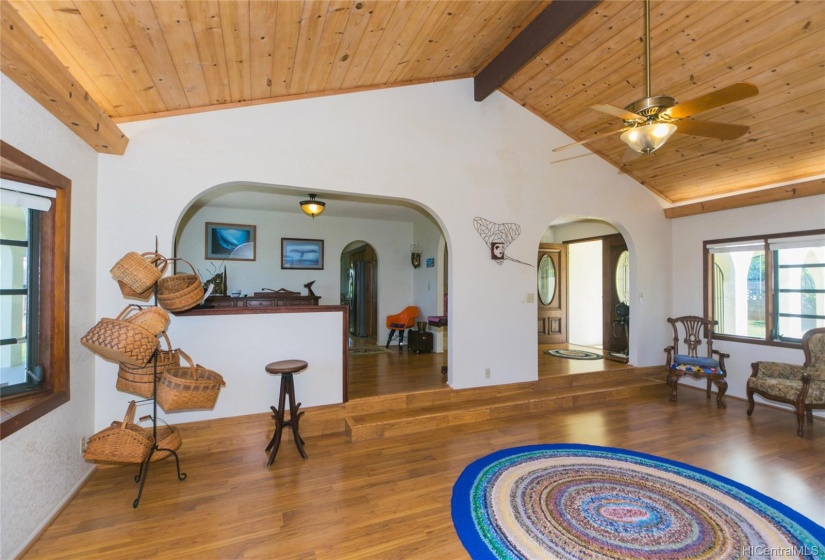 Pergo floors and matching vaulted ceiling and sunken living room with awning windows and wood trim give this home elegance! The separate dining room is  up the stairs  to the left.  Notice the arches.  Fans with lights throughout this home.