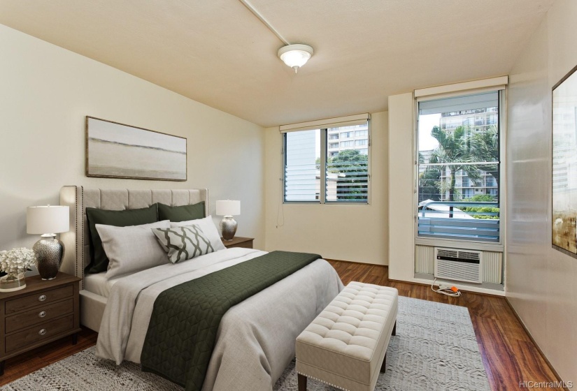 A generous bedroom with lots of room for large furniture. This room has roll down shades and an air conditioner. This photo has been virtually staged.