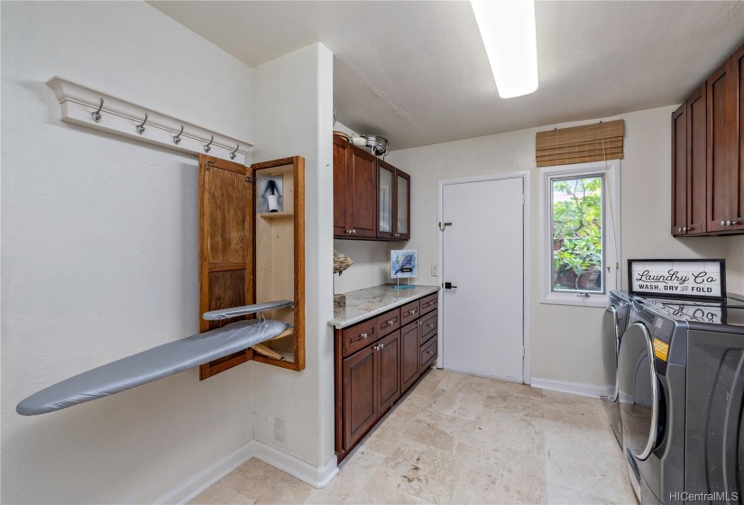 Large Laundry room with many cabinets and Granite Counter.