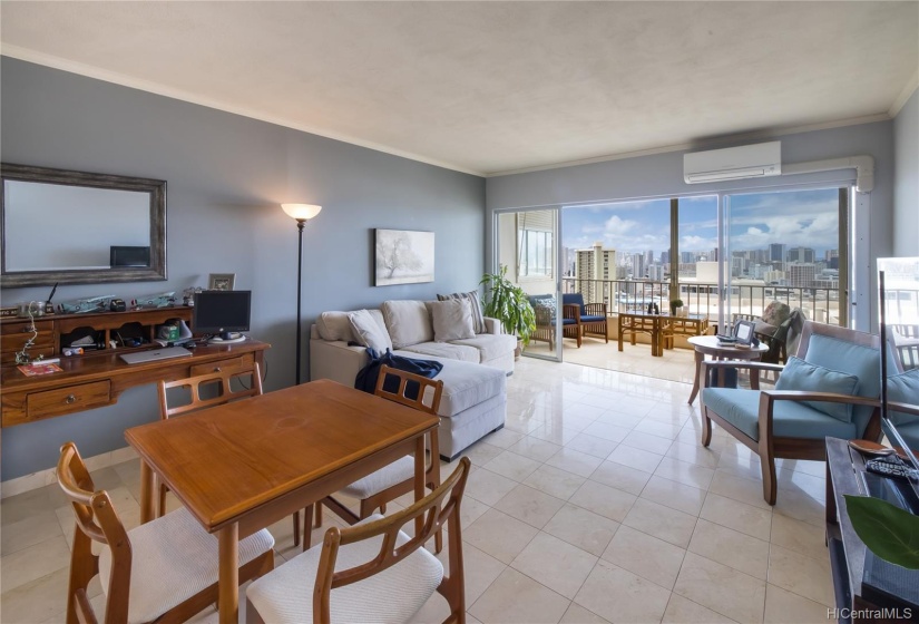 Open floor plan, bright and airy with gorgeous views.  Flooring is travertine and unit has a split AC in the living room as well as hurricane shutters. Views from the living area include ocean, city skyline, and diamond head.