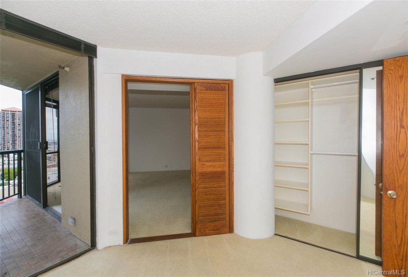 Bedroom #2 from a 3rd angle with no staging and showing the built ins in the closet and the adjoining lanai.