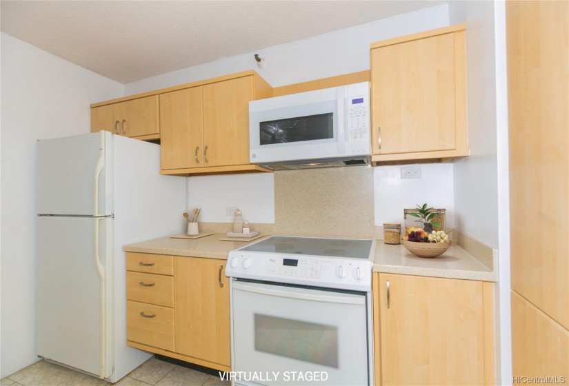 Newer kitchen cabinets are refaced and have soft close hinges and brushed nickel finishes in this bright, open kitchen.