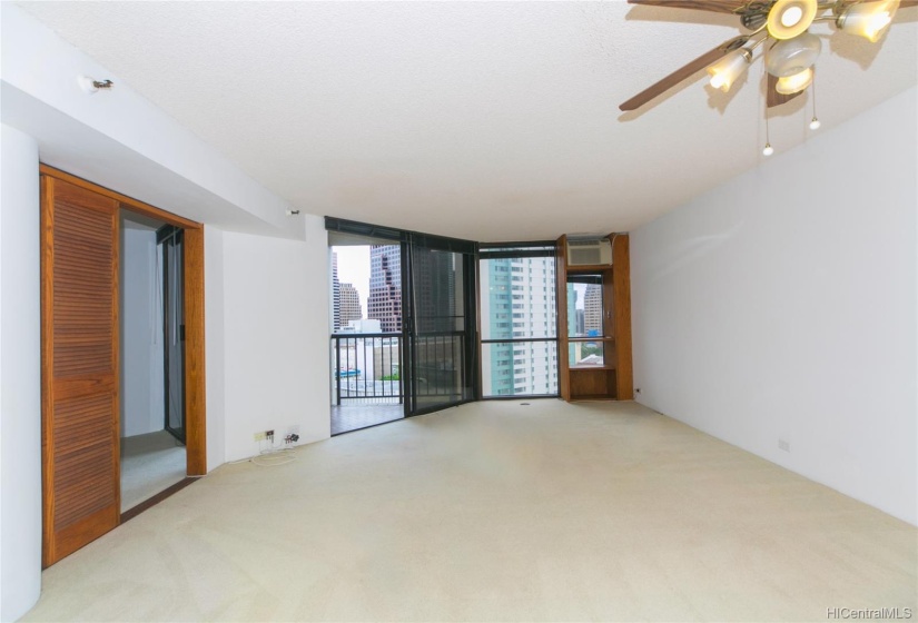 Similar angle of the spacious living room  and  dining area as the first shot, without the staging. Double doors on the right are Bedroom #2.