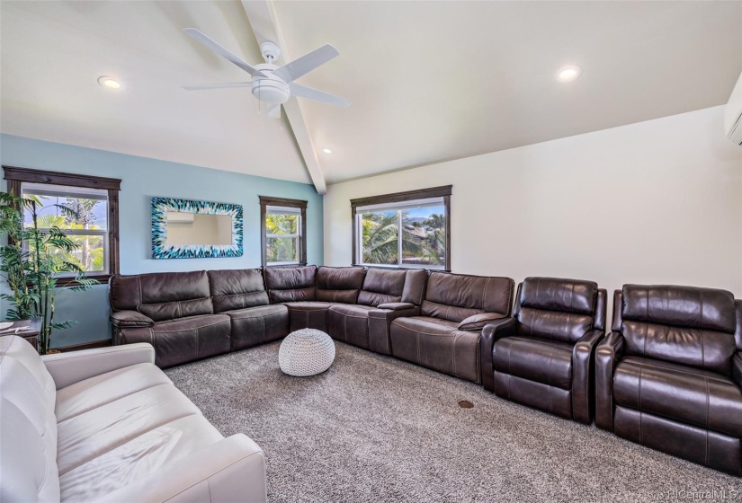 Relax in the large movie theatre room with black out blinds. TV (not pictured) is directly above the white couch.