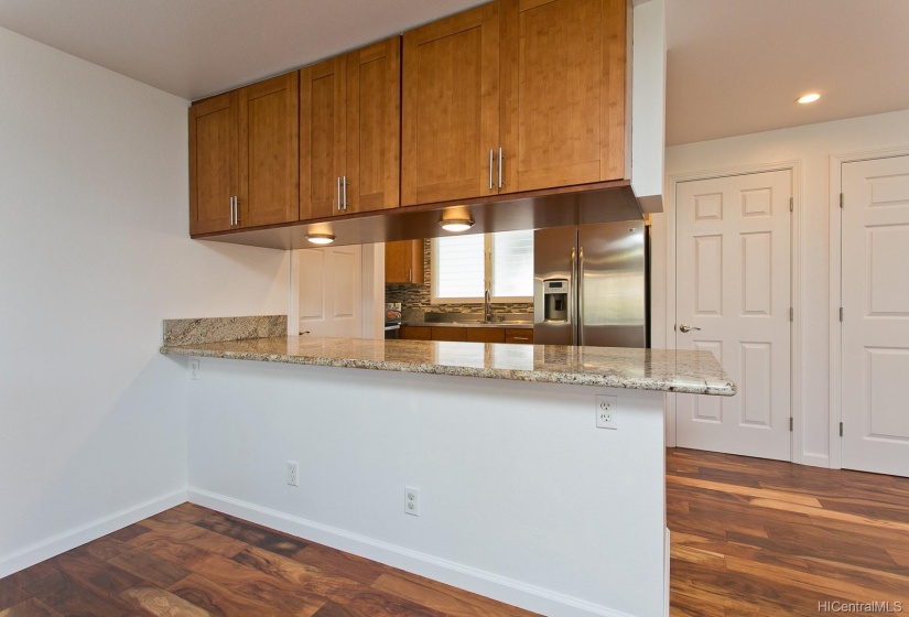 1st level kitchen. Stainless steel appliances, Granite countertops.  Stacked full size washer/dryer situated behind one of the background doors.