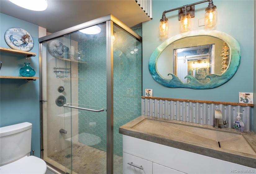 The hallway bathroom has also been tastefully remodeled with custom tiling, mirror and a slot sink vanity.