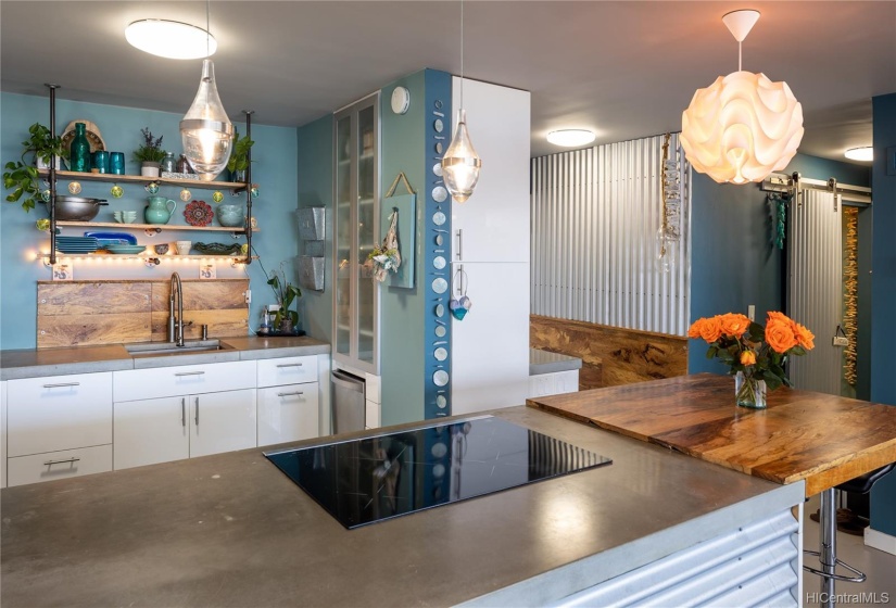 Induction cooktop, wood accents, shelving and clean lines.