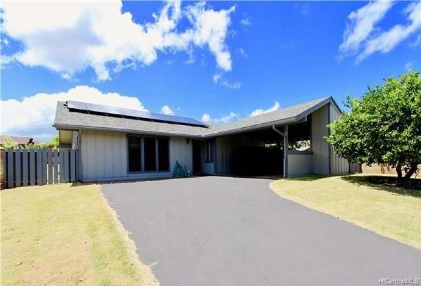 Exterior of the home with extra large driveway and parking for two cars in the carport