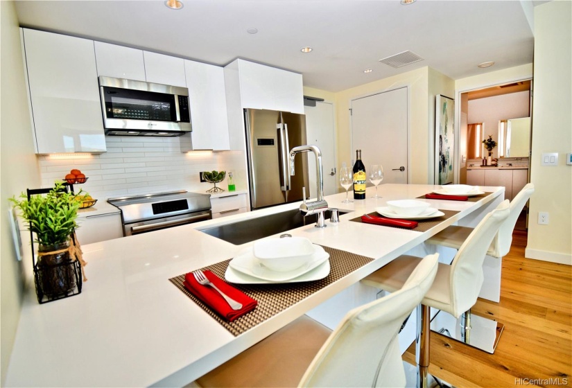 Contemporary, all white kitchen cabinets and countertop with Bosch appliances.