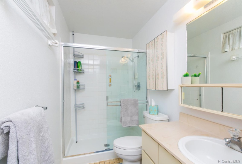 Masterbedroom ensuite with tile floors and walk in shower with glass doors.