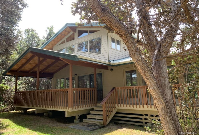 A view of the house and covered deck from the backyard.