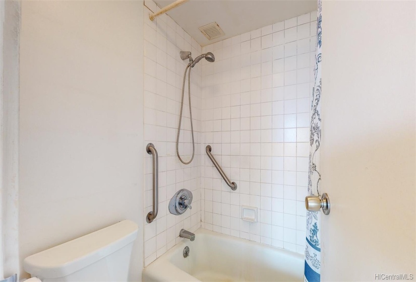 Original bathtub is cast iron with ceramic tile surround.