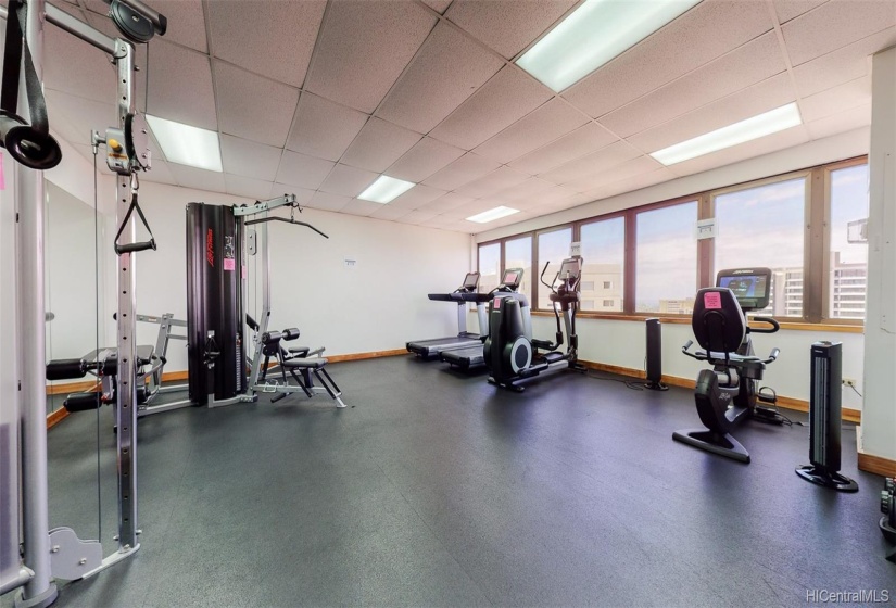 The rooftop gym includes weight and cardio machines with Diamond Head, Waikiki, and ocean views.