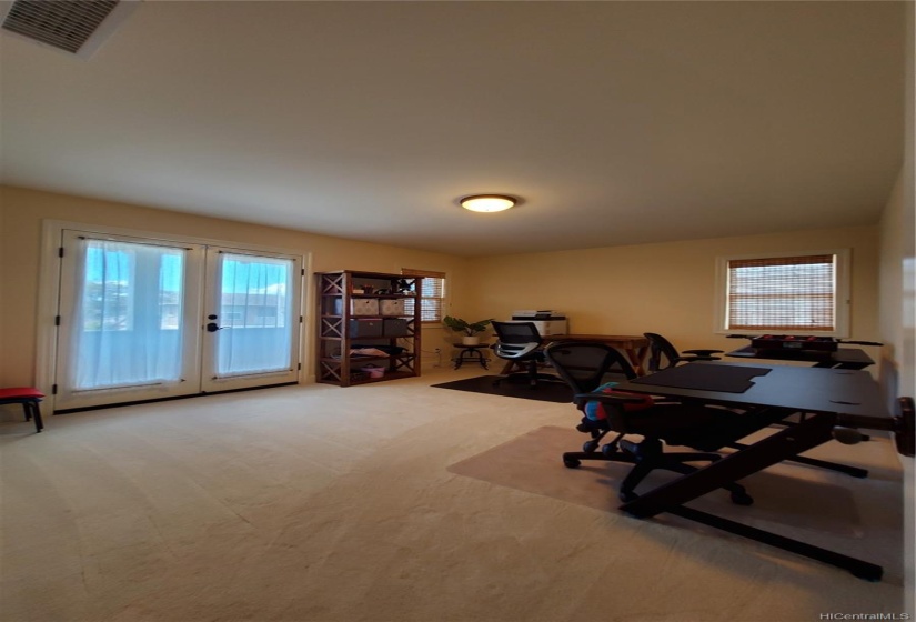 Upstairs bedroom #3 w/lanai entrance (room is used as an office / playroom) located towards the left front of the house.