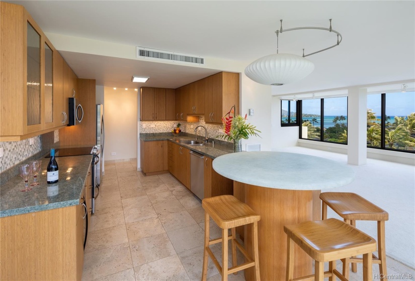 Lovely kitchen offers travertine flooring, bamboo cabinets and custom glass top table