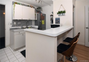 Bright and open kitchen with tiled backsplash and raised counter bar.