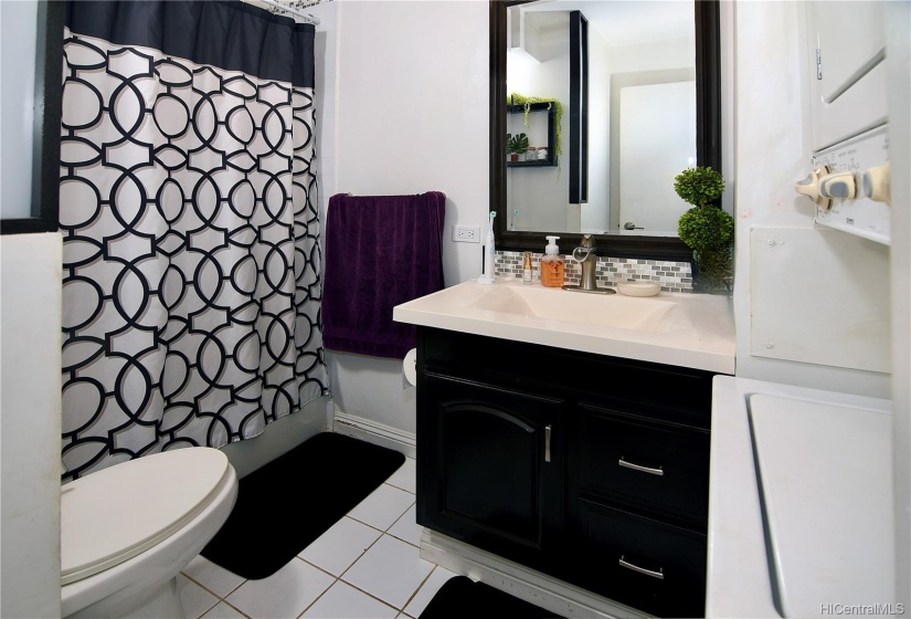 Tastefully upgraded bathroom features washer and dryer.