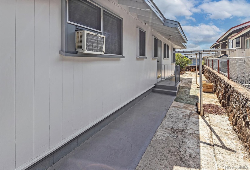 Side walk on right side of house with step and door entry to kitchen area.