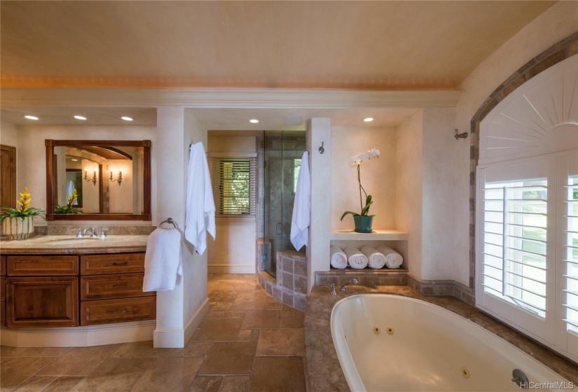 Spacious main bedroom bath offers double sinks and a vanity, as well as a spa tub with an ocean view and a separate shower.  Bathroom winds around to extra large walk-in closet that continues on to a laundry room that can also be accessed from a another door of hallway.