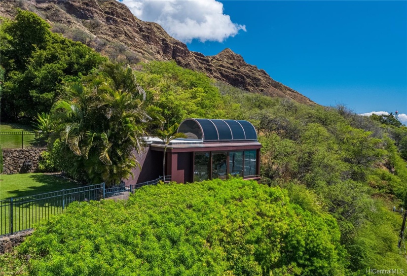 Award-winning guest cottage is a magical hidden retreat with sweeping ocean views through huge windows taking in all the nature around.