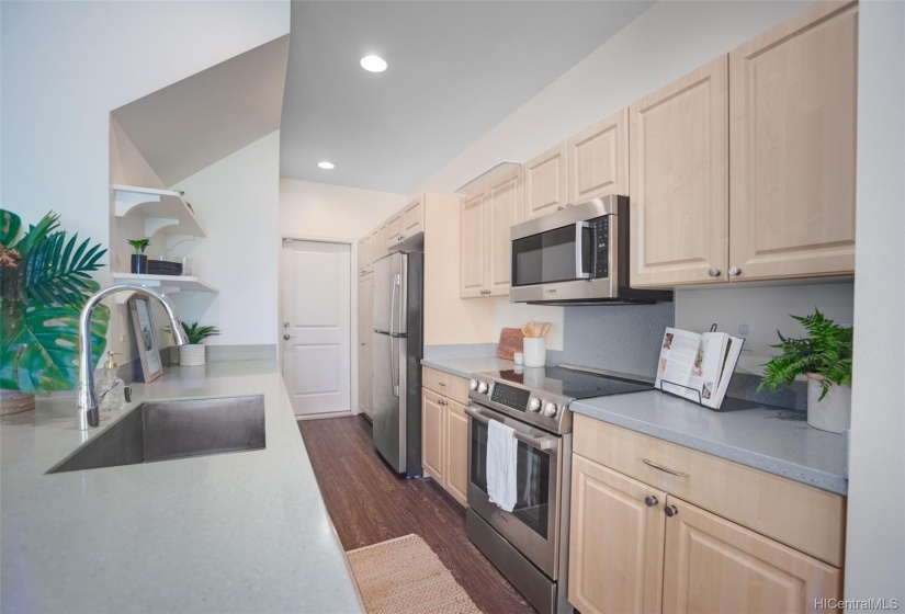 Updated kitchen with stainless steel appliances. The door leads to the garage.