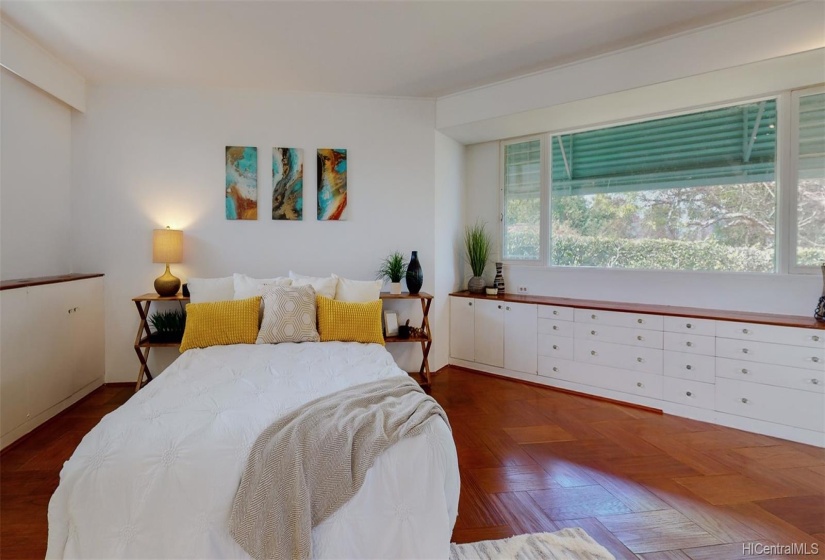 This spacious bedroom provides ample natural sunlight and drawer space.