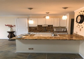 Nicely upgraded kitchen with granite countertops and pendant lighting.