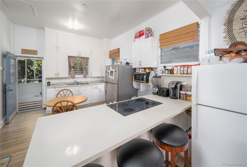 Updated kitchen with newer quartz island with glass top range