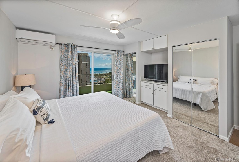 Large master bedroom with views of Ala Moana Beach park and Waikiki Yacht Club.