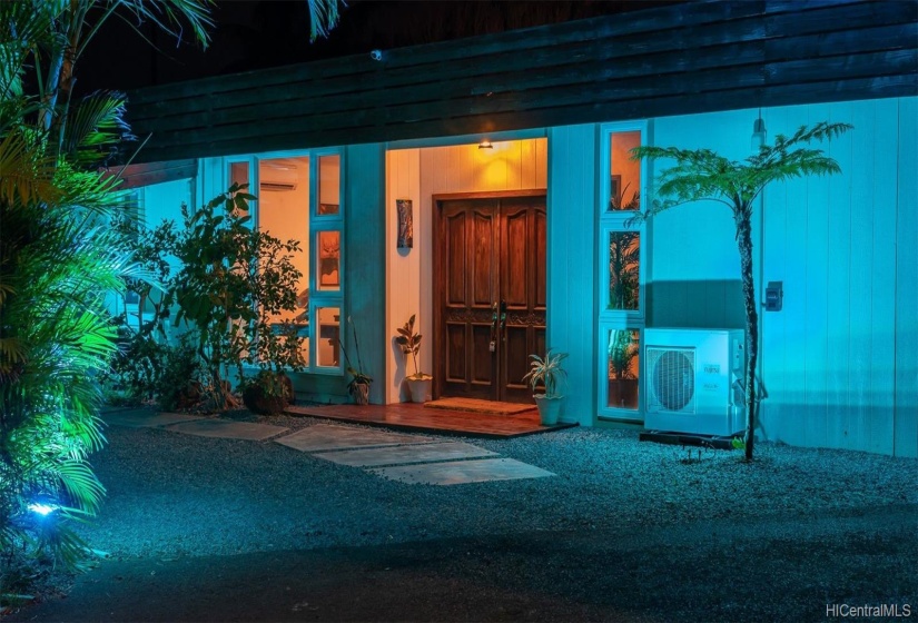 Rustic entrance reminiscent of Old Hawaii. as seen at night.