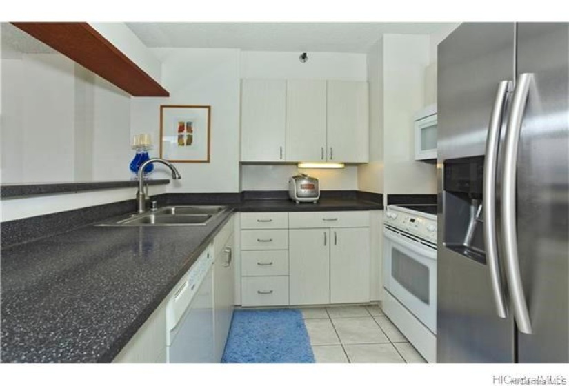 Full Kitchen featuring a dishwasher, range oven, microwave hood, and stainless steal refrigerator. Please note: unit is currently Tenant occupied.