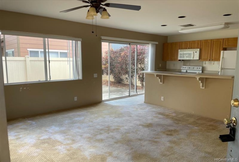 Living area with open floor plan and glass sliding door leading to yard.