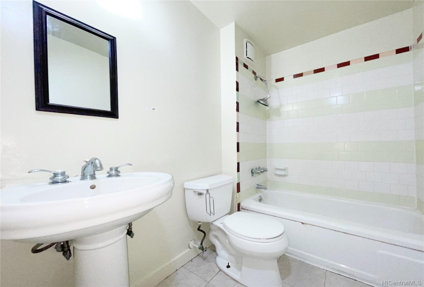 Clean and neat bathroom with tub and tiles.