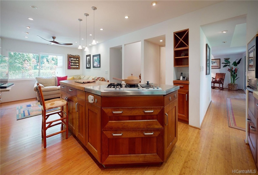 Gourmet Kitchen with Island includes lots of storage. The cooking Range features a retractable Hood not shown. The half bath door is to the left of phone nook. The next entry is stairs to 2nd level. The space nearest to the Family Area is entry to the Garage.  Easy access for bringing in your groceries!