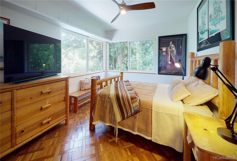 The second floor features the Master Bedroom Suite with inlaid wood flooring and large slider windows. Sleep to the sound of Manoa Stream which wraps around this side of the house.