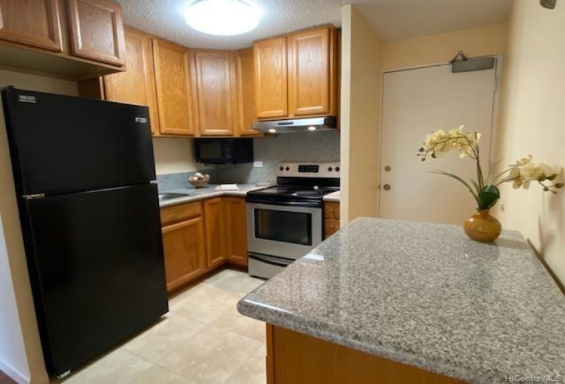 Remodeled kitchen with granite counters, mobile island with storage.