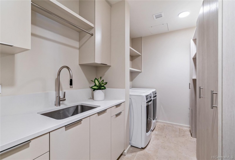 Large laundry area with wall of storage shelves.