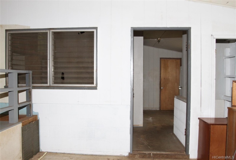 View of back room that can be a bedroom or storage room with door leading out to the backyard.