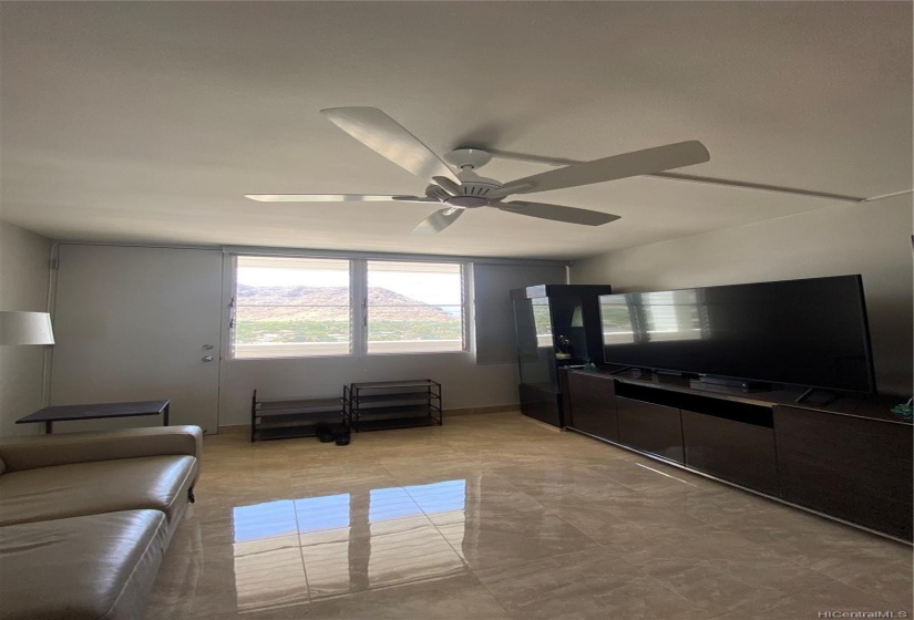 The living room is furnished with a leather sofa bed and and Italian entertainment center.  The windows open to mountain views and roller shades offers privacy.  The popcorn ceiling was removed and a new ceiling light fan was added in 2018.