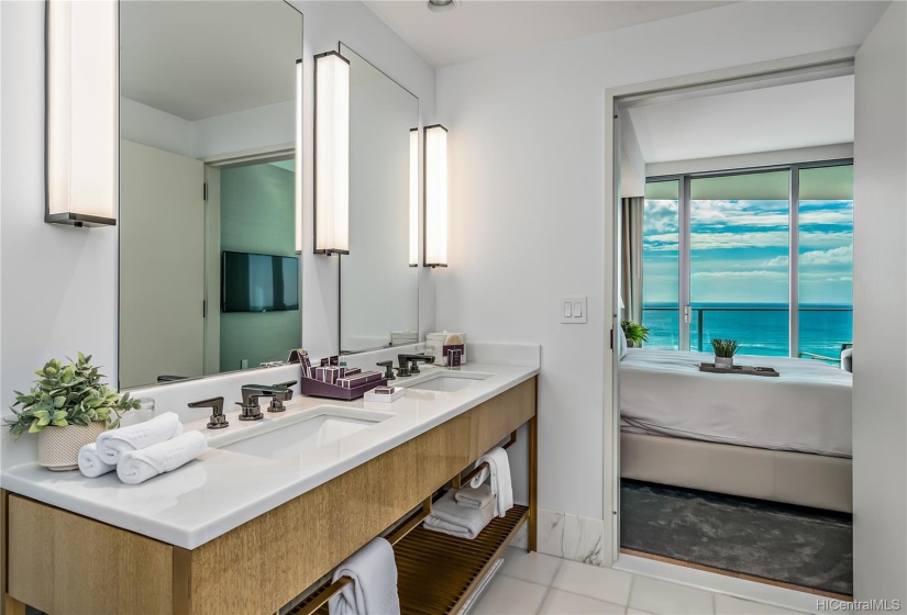 En-suite Guest bathroom features luxurious marble counter top, marble floors + ocean views.