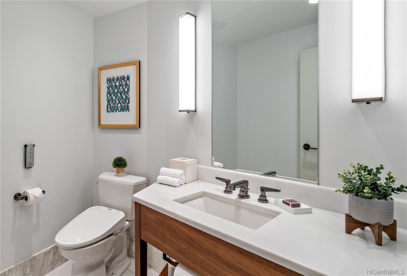 Guest Half Bathroom features marble countertop and Washlet.