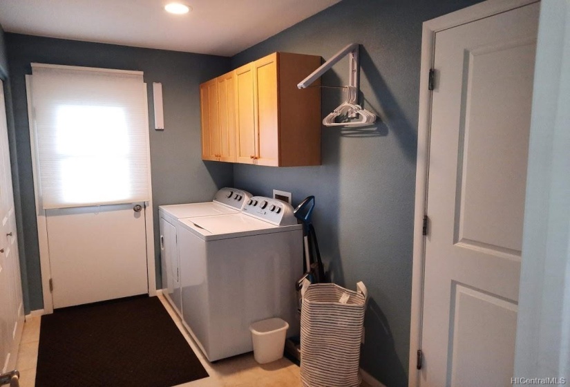 Specious laundry room with large closet & door to outside, perfect for entering after using the outdoor shower.