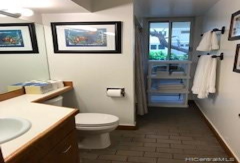 bathroom has tub and window for breezes