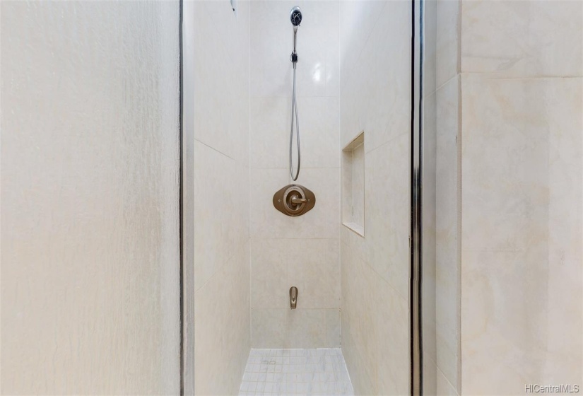 Shower with ceramic tile floor and surround.