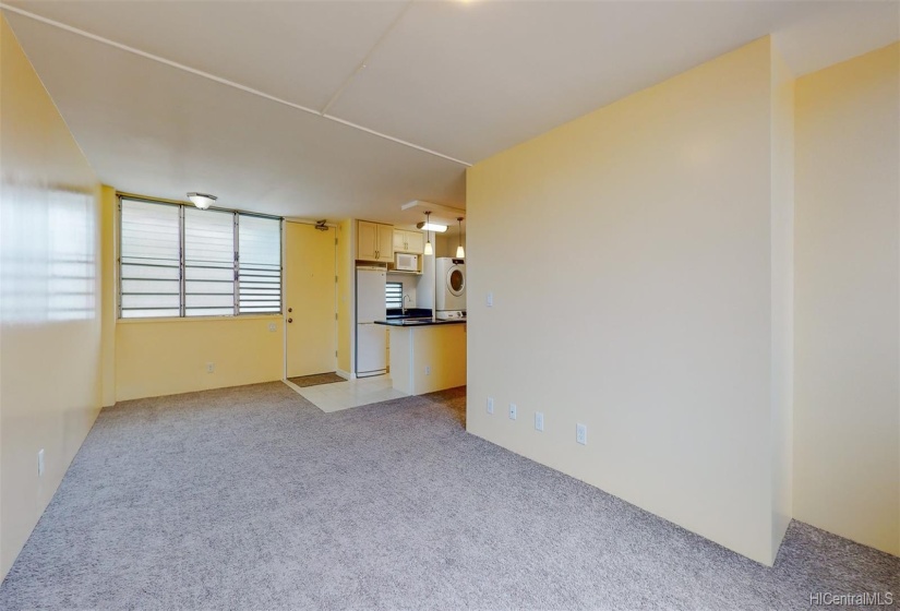 Looking back towards the front door and kitchen from the living room window. The area just off the kitchen to the left is a great space for a dining table or home office. The jalousie windows provide natural light and cool breezes.