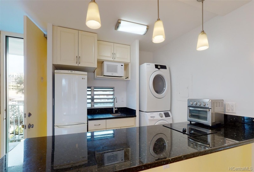 Renovations in kitchen included cabinets, granite counters, light fixtures and appliances. Microwave and toaster oven in photo are included with the property.