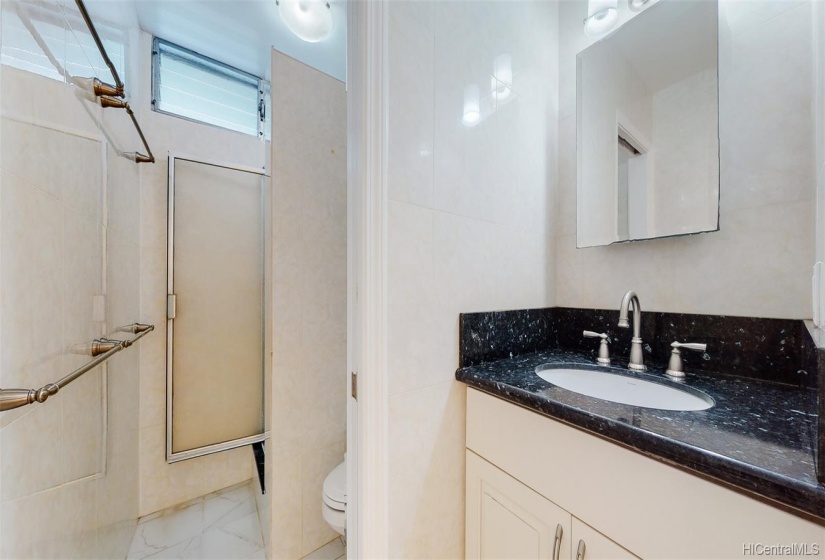 Bathroom was designed for efficiency and multiple users with pocket door in between vanity and shower areas as well as the entrance to the bathroom.  Renovation included ceramic tile flooring, shower, vanity, counter, sink and faucets, light fixtures, and smooth-coat ceiling.