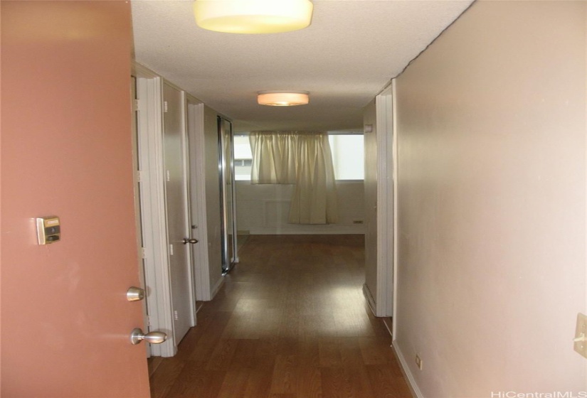 Hallway with bedrm to the left and bath and bedroom to the right and entry beyond